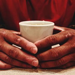 Midsection of man holding coffee cup