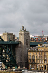 View of buildings in city against cloudy sky