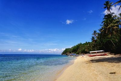 Scenic view of beach against blue sky