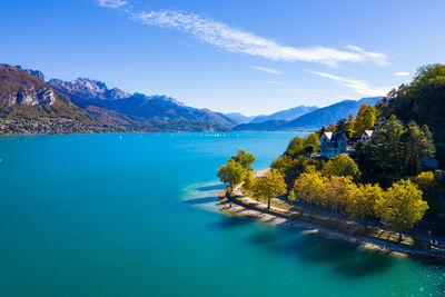 Scenic view of sea and mountains against blue sky