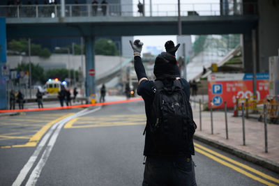 Rear view of man protesting on street in city