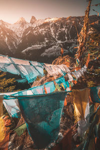 Mid distance view of man standing amid praying flags and snowcapped mountains