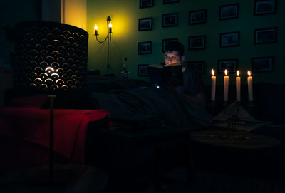 Man sitting in illuminated room