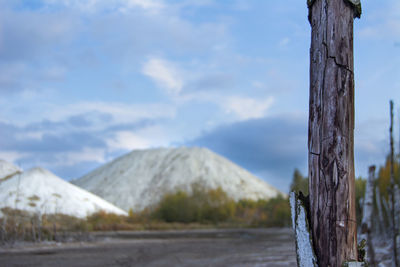 Wooden posts on mountain against sky