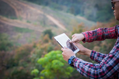 Midsection of man using mobile phone