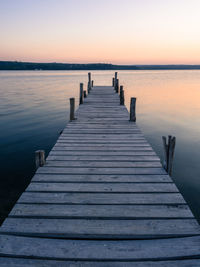 Wooden jetty on pier at sea against clear sky