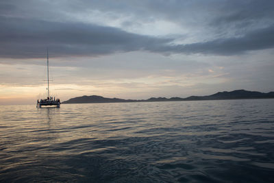 Boat sailing in sea at sunset