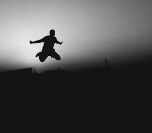 Low angle view of woman jumping in mid-air