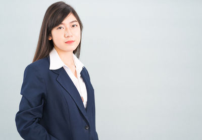 Portrait of a smiling young woman against white background