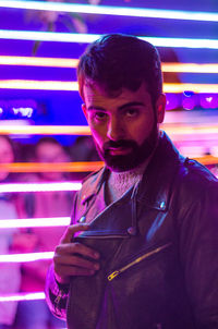 Portrait of bearded young man wearing leather jacket in nightclub