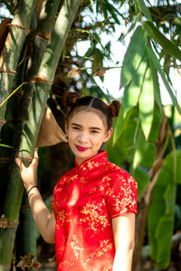 Portrait of smiling girl standing against plants