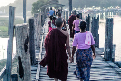 Rear view of women standing by railing in city