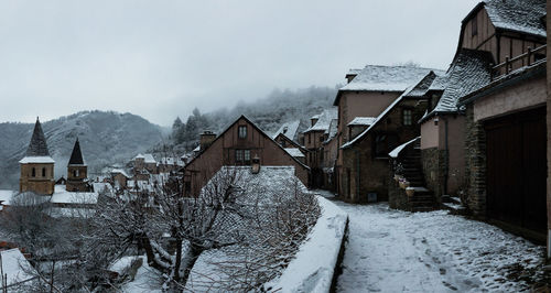 Snow covered houses against sky