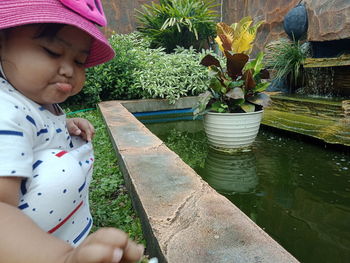 Midsection of cute girl with plants in yard