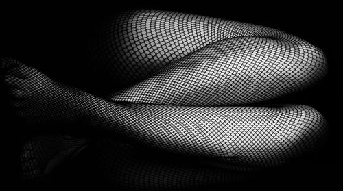 Low section of woman wearing fishnet stockings