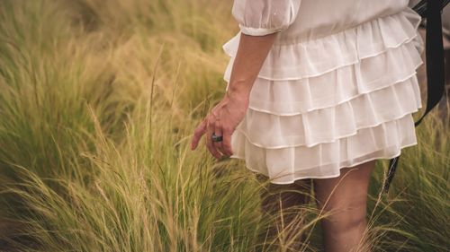 Low section of woman standing on field