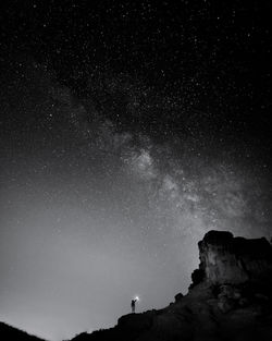 Low angle view of silhouette rock formation against sky