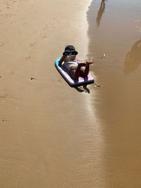 High angle view of boy sitting on beach