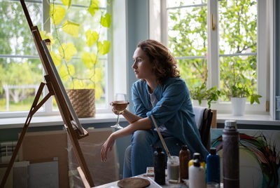 Woman with wine admiring painting