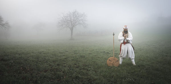 Woman standing on field against sky