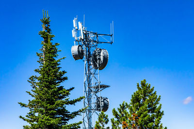 Low angle view of communications tower against blue sky