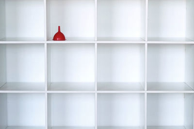 Full frame shot of white wall with red funnel