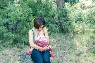 Young woman standing against tree