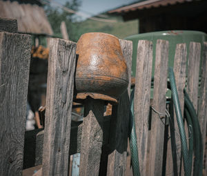 An old clay pot on the wooden fence