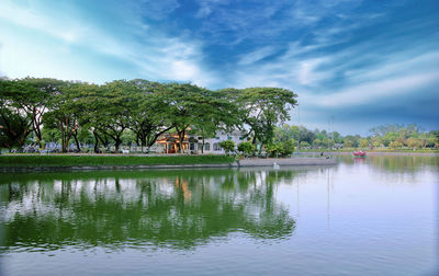 Scenic view of lake by trees against sky
