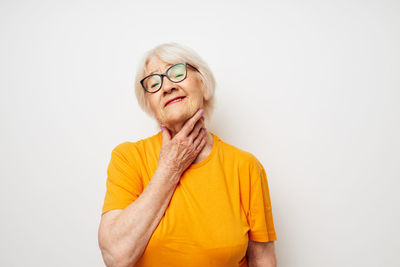 Portrait of young woman standing against white background