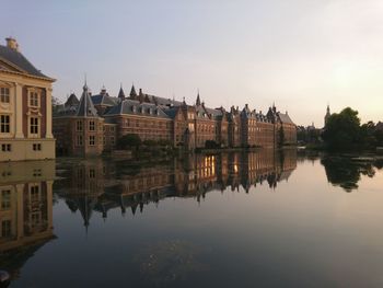 Reflection of buildings in lake at sunset