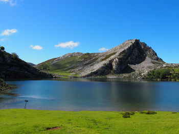 Scenic view of lake and mountains against blue sky