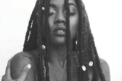 Young woman with dreadlocks against white background