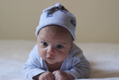 Cute baby boy lying on bed at home