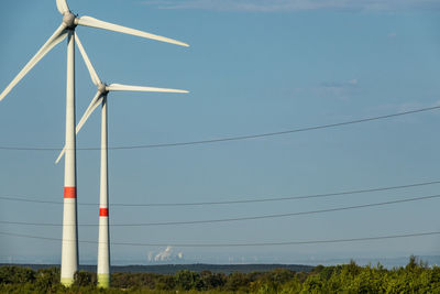 Low angle view of windmill on field against sky