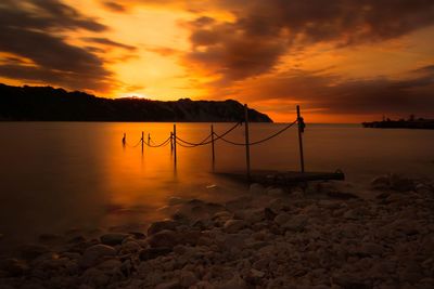 Scenic view of lake against orange sky