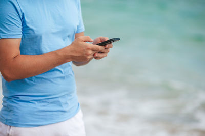 Midsection of man using mobile phone