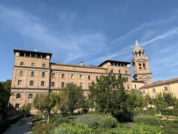 Low angle view of trees and building against sky