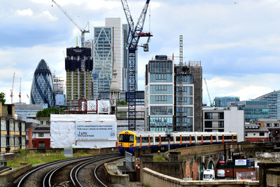 Buildings in city against cloudy sky