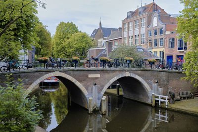 Utrecht, the netherlands. a line of bikes parked on a bridge over the oudegracht canal.