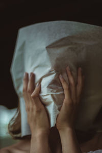 Low section of woman relaxing on bed