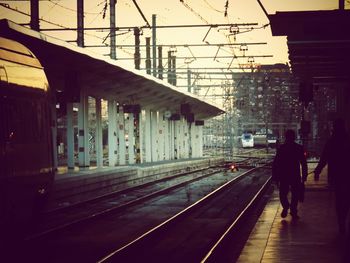 Rear view of people walking on railroad station platform