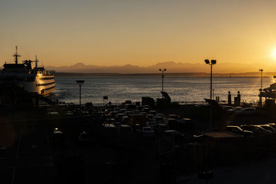 Ferry on sea against clear sky during sunset