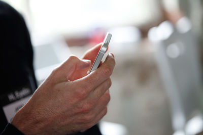 Close-up of cropped hand holding cigarette