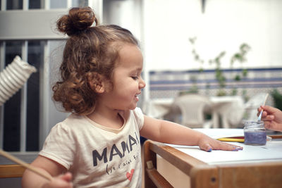 Children playing in an inner courtyard and painting with water paints