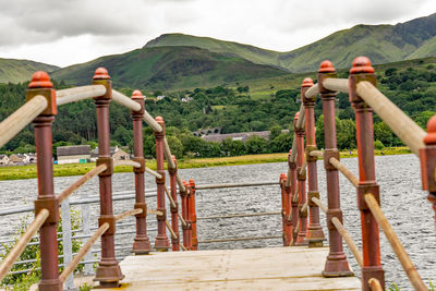 Wooden posts on mountain against sky