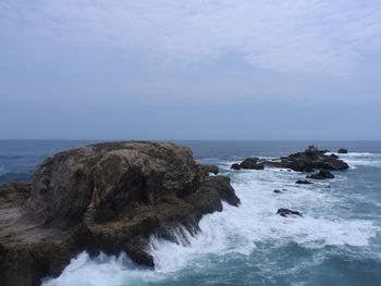 Rocks on beach against sky