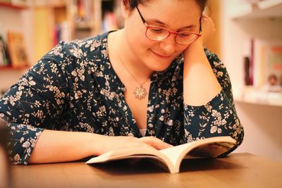 Portrait of young woman sitting on book