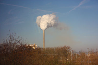 Smoke emitting from chimney against sky