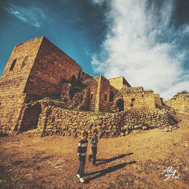 sky, lifestyles, architecture, leisure activity, building exterior, built structure, men, cloud - sky, person, history, rear view, casual clothing, tourism, famous place, travel destinations, religion, travel, standing